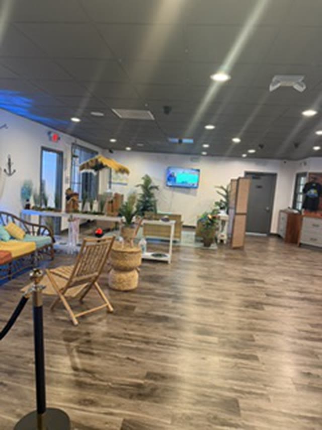 The Skunkies lounge: soft seating, potted plants and a wall screen.