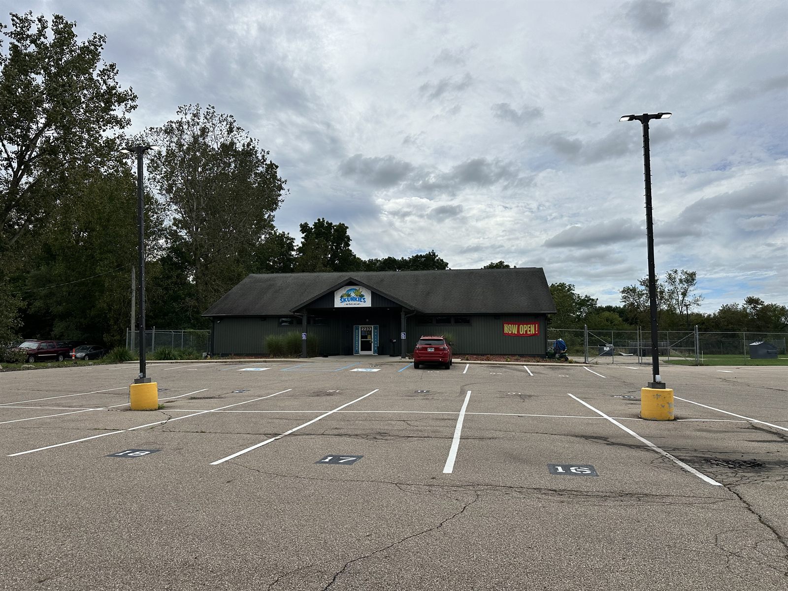 The Skunkies building at 2233 N Burdick St, Kalamazoo, seen across its wide parking lot.